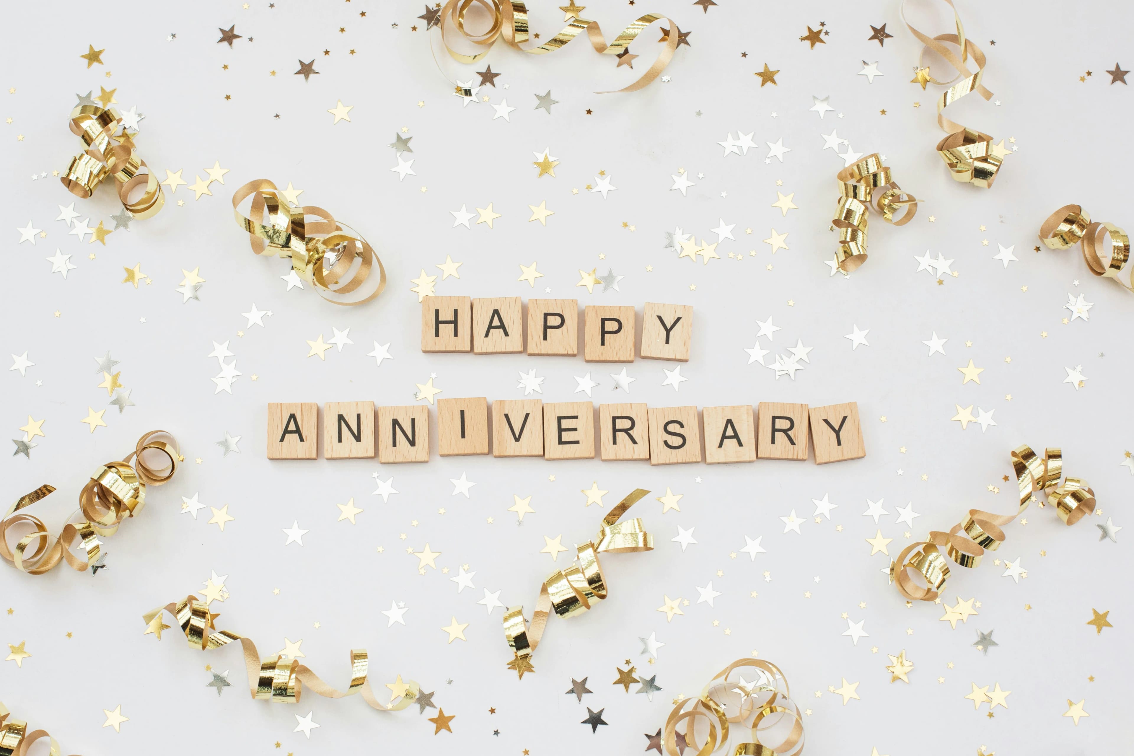 Happy Anniversary celebration with golden decorations and festive confetti