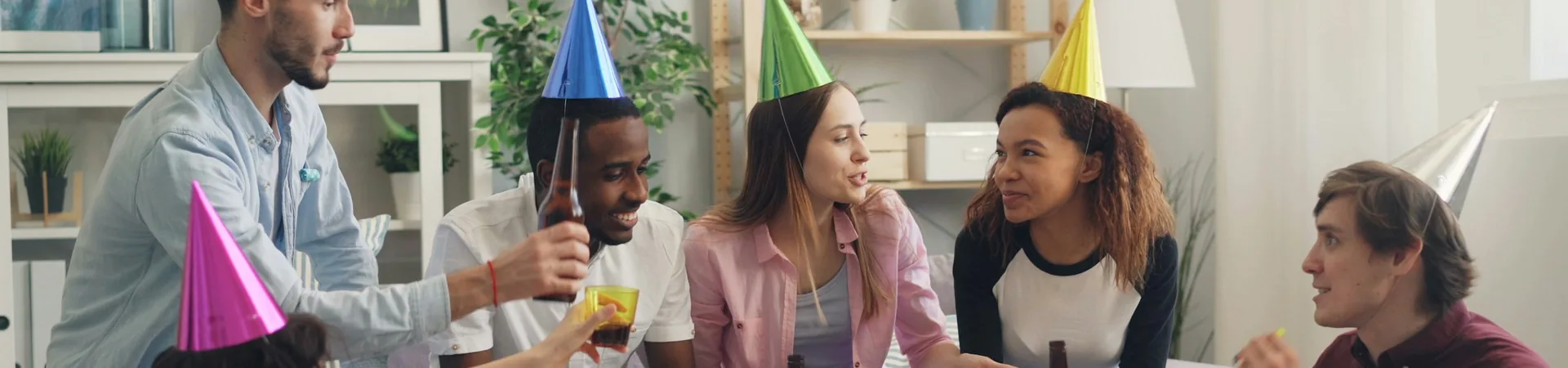 Friends wearing party hats sitting around a table